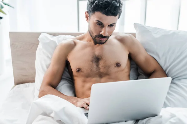 Красивый и сексуальный бирасовый мужчина с ноутбуком по утрам — Stock Photo