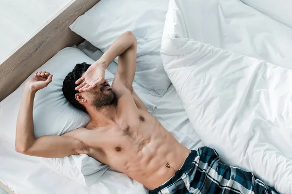 Vista superior de sexy bi-racial hombre despertando en la mañana - foto de stock
