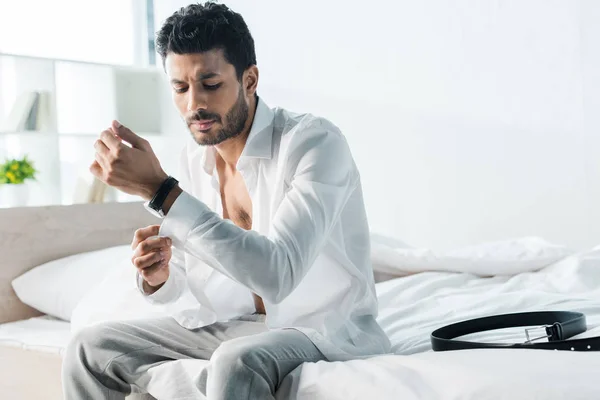 Schöner bi-rassischer Mann verkleidet sich und sitzt morgens auf dem Bett — Stockfoto