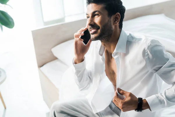 Vista ad alto angolo di uomo sorridente e bello bi-razziale che parla su smartphone al mattino — Foto stock