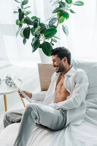 Bel homme bi-racial souriant lisant le journal le matin — Photo de stock