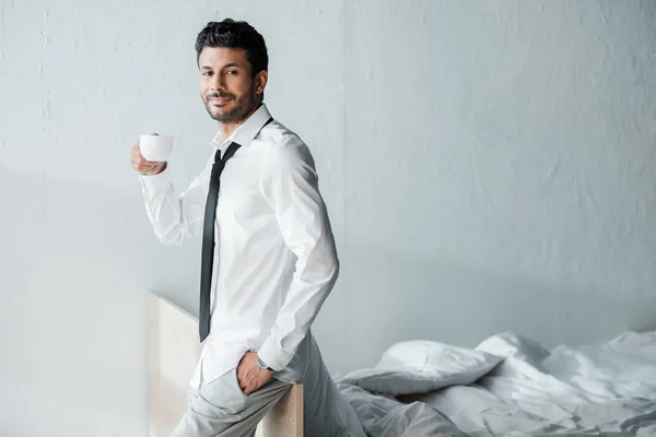 Schöner und lächelnder Geschäftsmann mit einer Tasse Kaffee am Morgen — Stockfoto