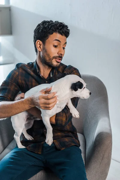 Shocked and handsome bi-racial man holding Jack Russell Terrier — Stock Photo