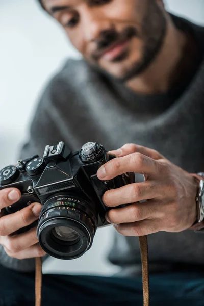 Foco seletivo de sorrir bi-racial homem segurando câmera digital — Fotografia de Stock