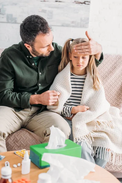 Padre preocupado tocando la frente de la hija enferma — Stock Photo