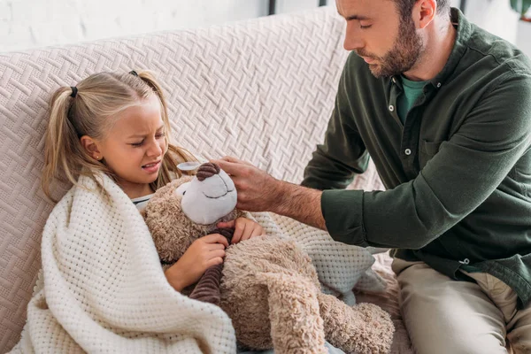 Père attentif donnant des médicaments à la fille malade — Photo de stock