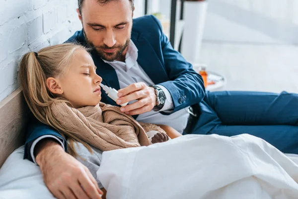 Caring father holding nasal spray near diseased daughter — Stock Photo