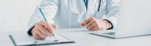 Cropped view of doctor writing prescription on clipboard, panoramic shot — Stock Photo
