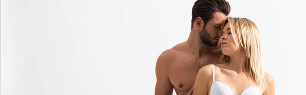 Tiro panorâmico de homem sem camisa apaixonado abraçando mulher sensual, isolado no branco — Fotografia de Stock