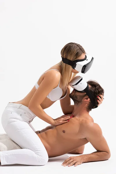 Casal sensual em realidade virtual headsets abraçando no branco — Fotografia de Stock