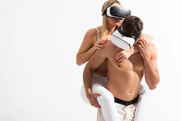 Sexy couple in Virtual reality headsets piggybacking isolated on white — Stock Photo