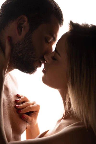 Silueta de pareja atractiva besos aislados en blanco - foto de stock