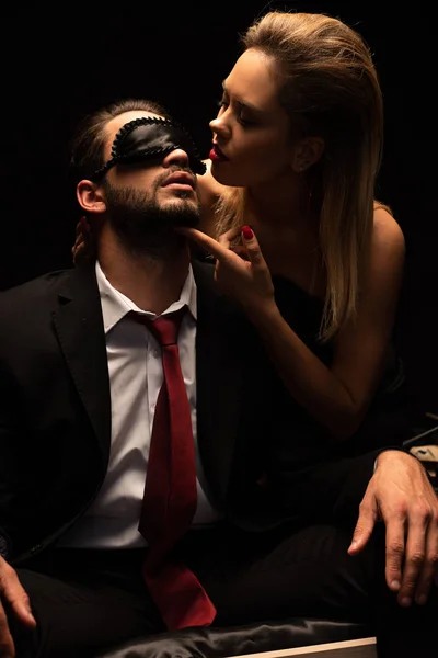 Attrayant sexy femme étreignant l'homme dans le masque sur le lit dans la chambre noire — Stock Photo