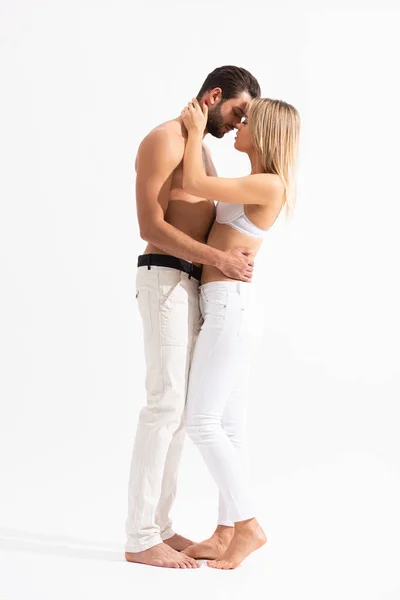 Hermosa pareja seductora de amantes abrazándose en blanco - foto de stock