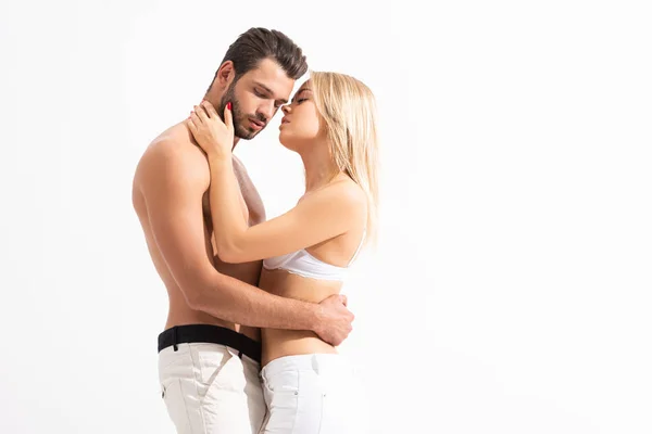 Casal sensual em jeans brancos abraçando isolado no branco — Fotografia de Stock