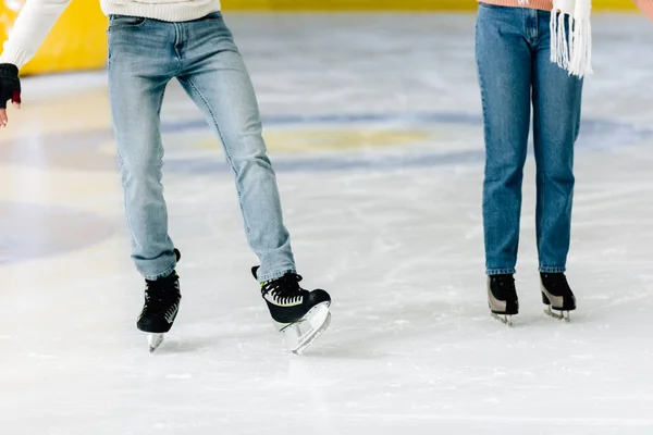 Visão cortada de jovem mulher ensinando o homem a patinar em uma pista — Fotografia de Stock