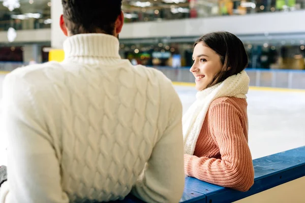 Young couple in sweaters spending time on skating rink — Stock Photo
