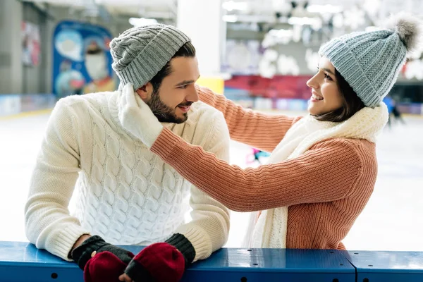 Beau couple joyeux portant des chapeaux sur la patinoire — Photo de stock