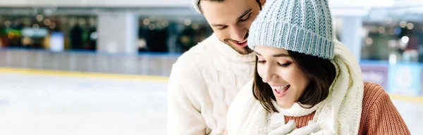 Panoramic shot of excited couple spending time on skating rink — Stock Photo