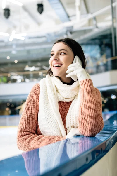 Счастливая молодая женщина разговаривает на смартфоне на катке — стоковое фото