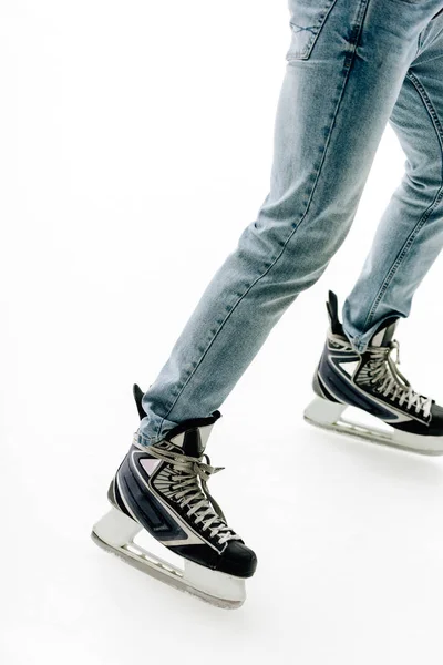 Cropped view of man in jeans and skates skating on rink — Stock Photo