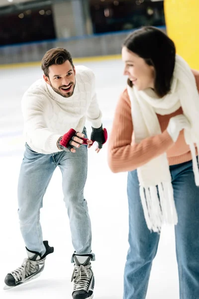 Excité jeune couple avoir plaisir tout en patinant sur la patinoire — Photo de stock