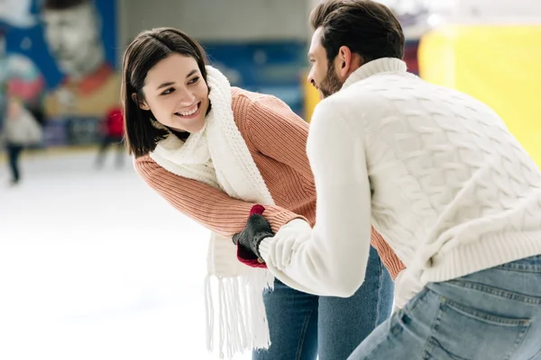 Fröhliches junges Paar hat Spaß auf der Eisbahn — Stockfoto