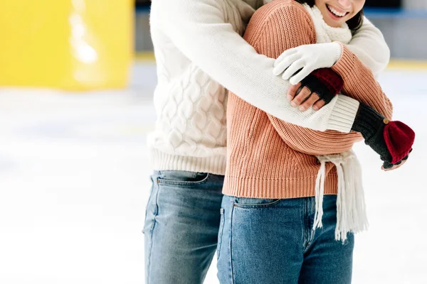 Ausgeschnittener Blick auf junges Paar, das sich auf Eisbahn umarmt — Stockfoto