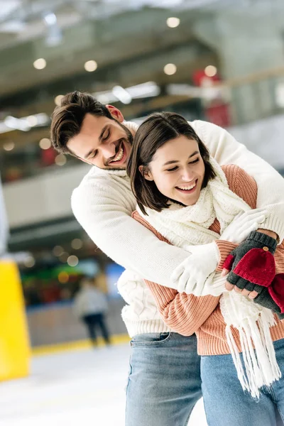 Alegre casal abraçando e passar tempo na pista de patinação — Fotografia de Stock
