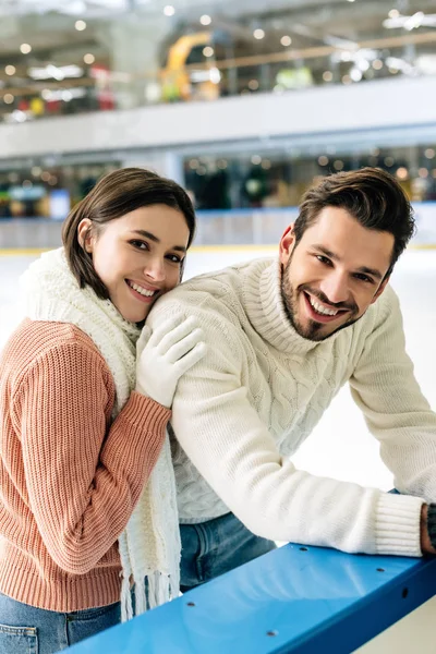 Jeune couple en pull passer du temps sur la patinoire — Photo de stock