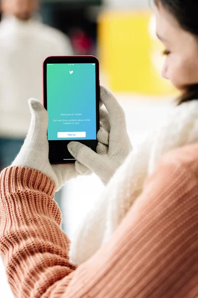 KYIV, UCRAINA - 15 NOVEMBRE 2019: vista ritagliata della donna in guanti che tiene smartphone con app twitter sullo schermo — Foto stock