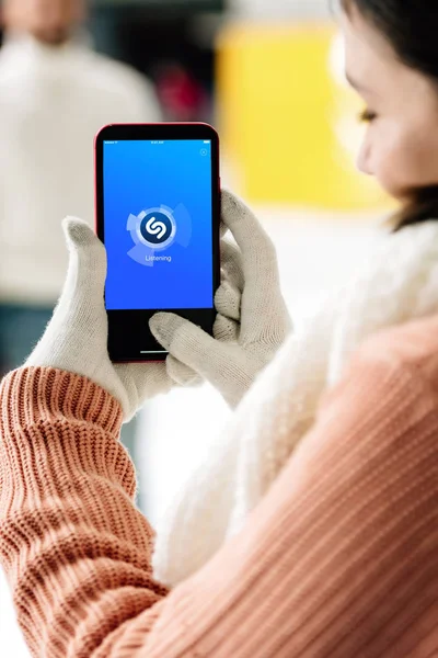 KYIV, UKRAINE - 15 NOVEMBRE 2019 : vue recadrée d'une femme portant des gants tenant un smartphone avec une application shazam à l'écran — Photo de stock