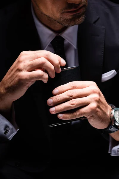 Cropped view of businessman holding flask isolated on black — Stock Photo