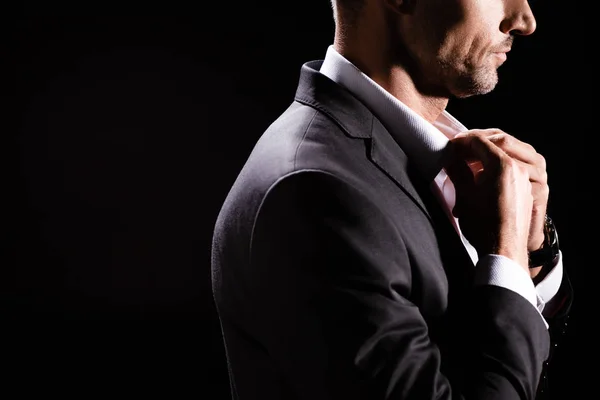 Cropped view of businessman buttoning up shirt isolated on black — Stock Photo