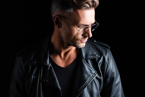 Stylish man in leather jacket looking away isolated on black — Stock Photo