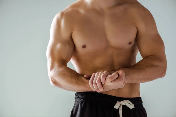 Cropped view of sexy muscular bodybuilder with bare torso posing isolated on grey — Stock Photo