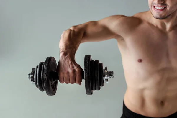 Visão parcial do fisiculturista muscular sexy com exercício de tronco nu com halteres isolados em cinza — Fotografia de Stock