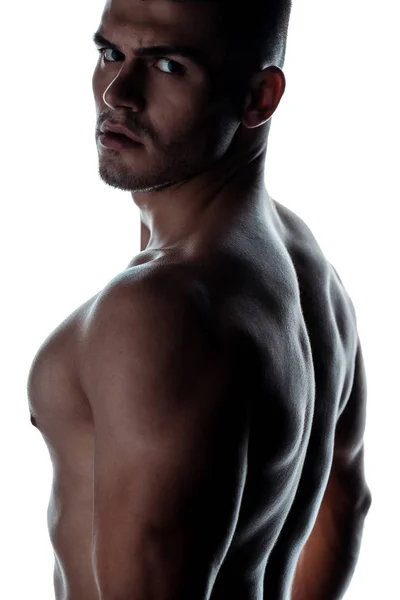 Сексуальний м'язистий культурист з голим торсом позує в тіні ізольовано на білому — стокове фото