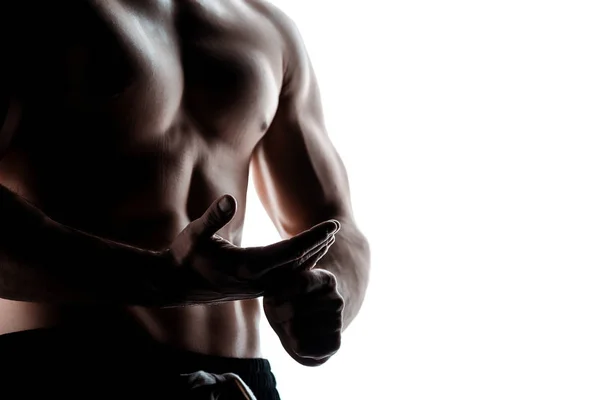 Partial view of sexy muscular bodybuilder with bare torso posing in shadow isolated on white — Stock Photo