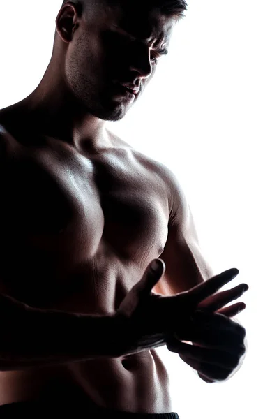 Musclé bodybuilder sexy avec torse nu posant dans l'ombre isolé sur blanc — Photo de stock