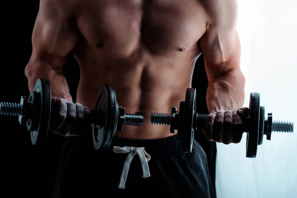 Ausgeschnittene Ansicht von sexy muskulösen Bodybuilder mit nacktem Oberkörper beim Training mit Hanteln — Stockfoto