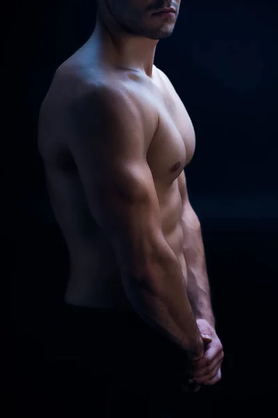 Vista lateral de sexy musculoso culturista con torso desnudo posando aislado en negro - foto de stock