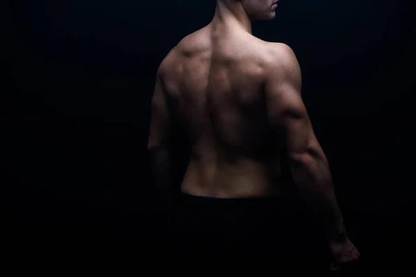 Partial view of sexy bodybuilder with muscular back isolated on black — Stock Photo