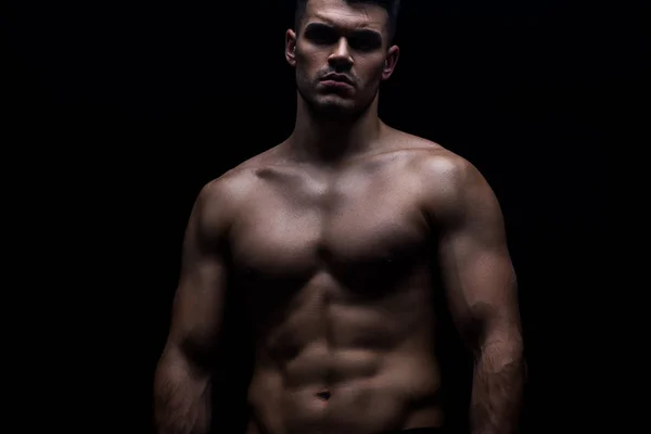 Sexy musculoso culturista con torso desnudo aislado en negro - foto de stock