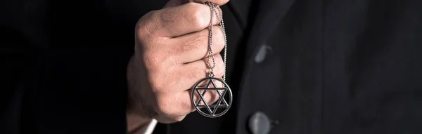 Panoramic shot of jewish man holding star of david necklace — Stock Photo