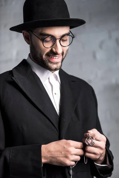 Красивий і усміхнений єврейський чоловік тримає зірку Девідського намиста — стокове фото