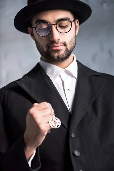 Handsome jewish man in glasses holding star of david necklace — Stock Photo