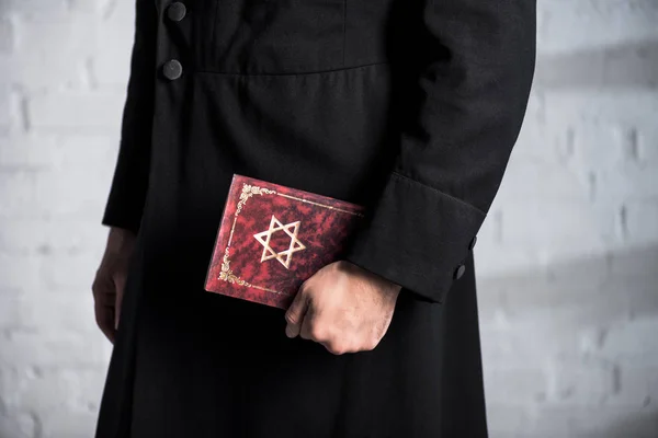 Vista cortada de jovem judeu segurando tanakh — Fotografia de Stock