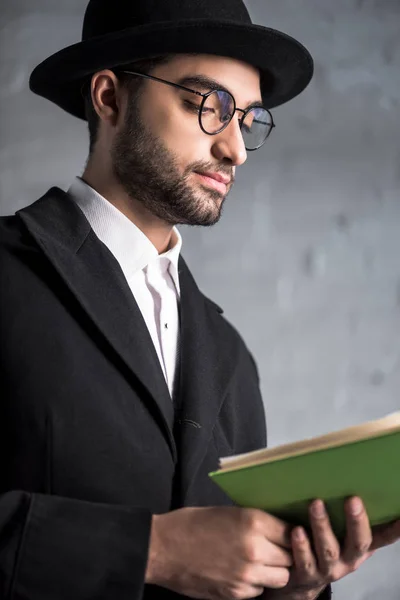 Handsome and young jewish man in glasses reading book — Stock Photo