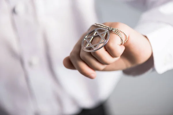 Cropped view of jewish boy in shirt holding star of david necklace — Stock Photo